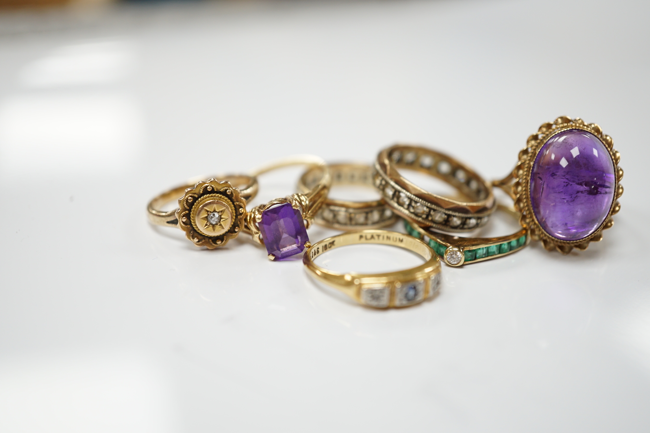 Five assorted 9ct and gems set rings including cabochon amethyst, gross weight 15.1 grams, an 18ct and gem set ring and a 585 emerald and diamond set ring